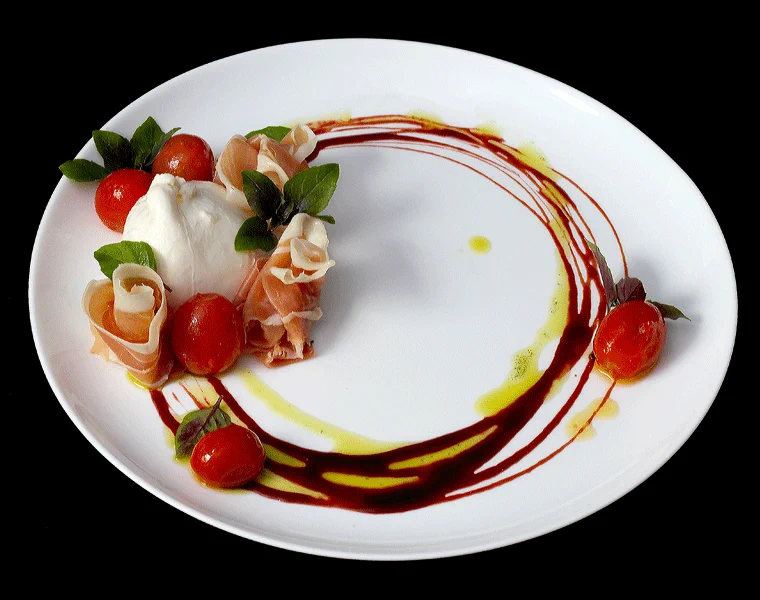 Ciranda da Bailarina: burrata, tomates-cereja e presunto em prato branco com um círculo de calda escura